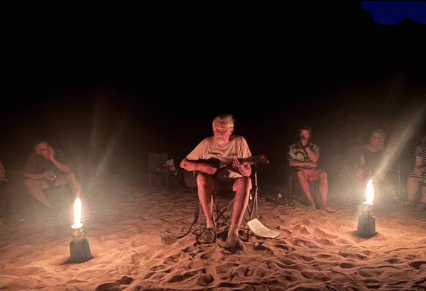 John Wakefield playing guitar on the banks of the Colorado River (image & text by the author)